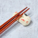 Sleeping white cat chopstick rest